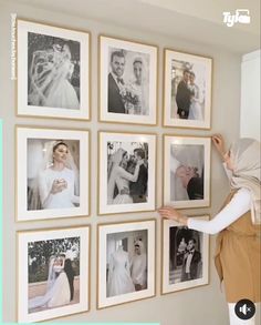 a woman standing next to a wall with pictures on it