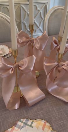 the table is set with pink napkins and gold candlesticks, which are adorned with bows