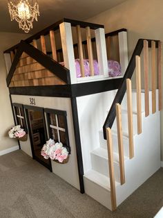 there is a doll house with stairs to the second floor and flowers on the steps