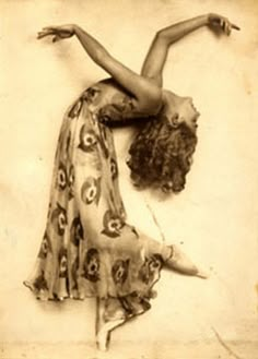 an old fashion photo of a woman in a long dress with her arms stretched out