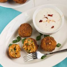 a white plate topped with food next to a bowl of dip