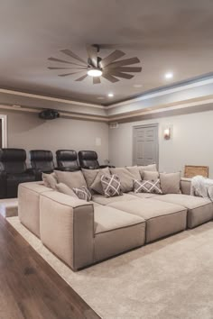 a living room filled with furniture and a ceiling fan