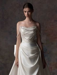 a woman in a white dress with pearls on it