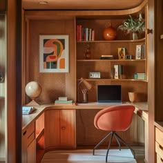 a home office with an orange chair in the corner and bookshelves on the wall