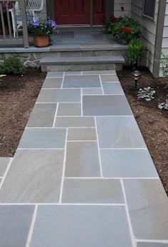 a stone walkway in front of a house