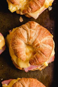 ham and cheese croissants with melted cheese on them are ready to be eaten