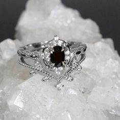 a close up view of a ring on top of some crystal rocks, with the center stone surrounded by small white diamonds