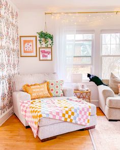 a living room filled with furniture and a cat sitting on top of the couches