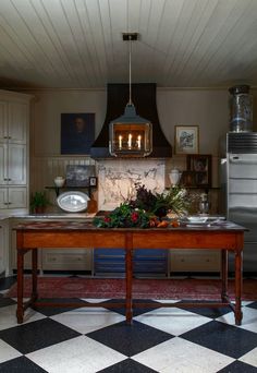 a kitchen with checkered flooring and an island in front of the stove top