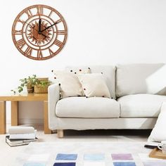 a living room with a white couch and large clock on the wall