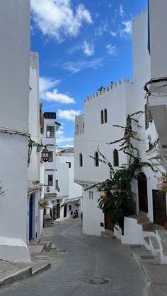 an empty street with white buildings and blue sky