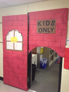 a red building with a sign on it that says kids only in front of the door