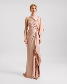 Elegantly draped in satin, this blush-colored evening dress features an asymmetrical neckline and a gracefully ruffled slit on the side. Perfect for formal occasions, its smooth satin fabric ensures a luxurious feel and a flattering silhouette. Draped Dress Pattern, Drop Waist Gown, Draping Dress, Dramatic Classic, Soft Dramatic, Asymmetrical Neckline, Draped Dress, Lace Design, Asymmetrical Dress