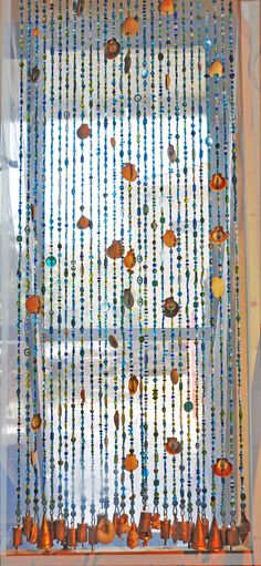 a window with beads hanging from it's side and a curtain made out of glass beads