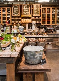 the inside of a store filled with lots of wooden shelves and buckets full of flowers