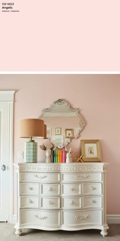 a white dresser sitting next to a pink wall