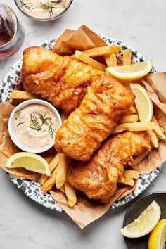 fish and chips on a plate with dipping sauce