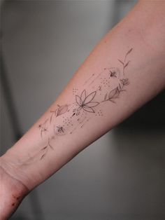 a woman's arm with a flower tattoo on it