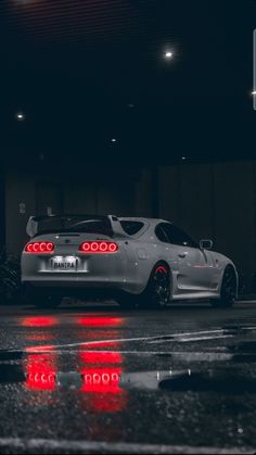 a white sports car parked on the street at night