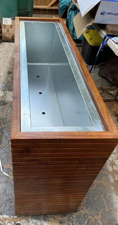 a wooden box with glass in it sitting on the ground