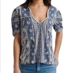 Lucky Brand Blue Floral Print Short Sleeve Cotton Top With Tie Accent Size Small Blue Pink And White Cotton Blend Machine Washable New With Tags Bohemian Blue Tops With Relaxed Fit, Blue Bohemian Relaxed Fit Tops, Bohemian Blue Relaxed Fit Tops, Blue Bohemian Short Sleeve Tops, Casual Blue Floral Print Blouse, Blue Bohemian Cotton Tops, Blue Cotton Bohemian Tops, Blue Bohemian Tops For Day Out, Bohemian Blue Cotton Tops