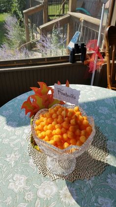 a bowl filled with oranges sitting on top of a table