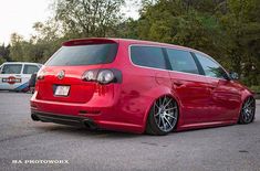 a red vw golf wagon parked in a parking lot