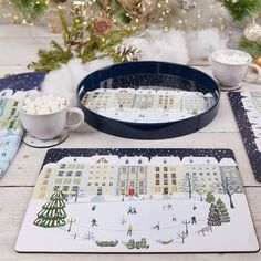 two placemats on a table with christmas decorations in the background and a cake pan filled with marshmallows