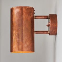 a copper colored wall light with a brown shade