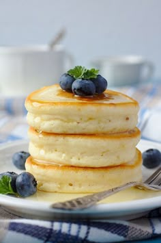 a stack of pancakes with blueberries and syrup