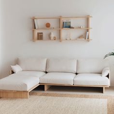 a white couch sitting next to a wooden shelf