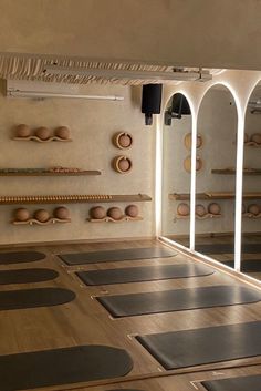 yoga mats are lined up on the floor in front of mirrors and wall mounted shelves