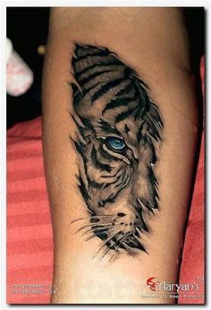 a black and white tiger tattoo with blue eyes on the leg, it looks like he is