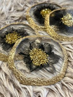 three black and gold coasters sitting on top of a fur rug