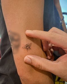 a person with a small tattoo on their left arm holding onto the side of her leg