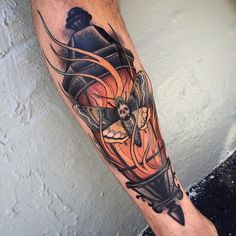 a man's leg with a tattoo on it that has an image of a skull and a lantern