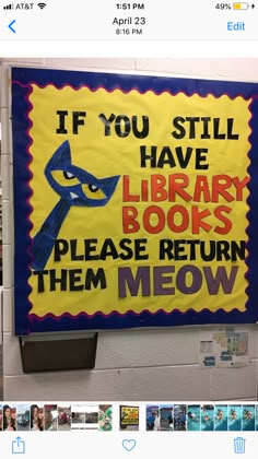 a library sign is posted on the wall in front of bookshelves and shelves