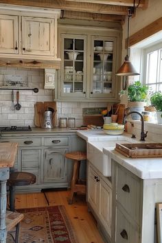 an old fashioned kitchen with wooden floors and white painted cabinets is pictured in this image