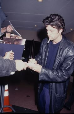 a young man is signing autographs for someone at an event in the dark room