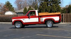 a red and white truck parked in a parking lot