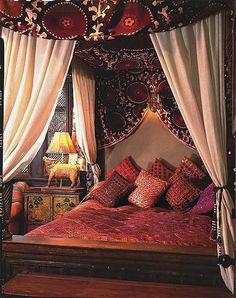 the canopy bed is made up with red and white pillows