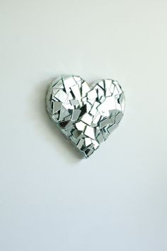 a heart shaped mirror hanging on the wall