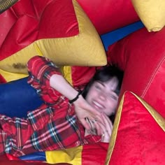 a woman laying on top of a red and yellow inflatable slide