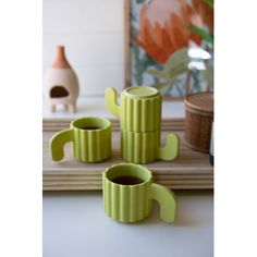 three green cups sitting on top of a table