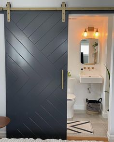 an open door leading to a bathroom with a sink and toilet in the background,