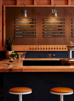 a bar with three stools in front of it and several menus on the wall