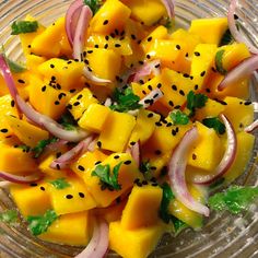 a glass bowl filled with mango and onions