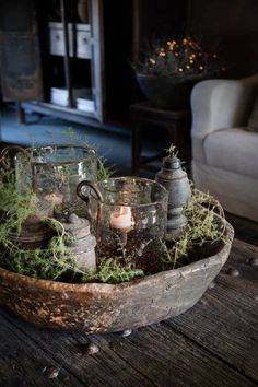 a wooden tray filled with glass cups and plants