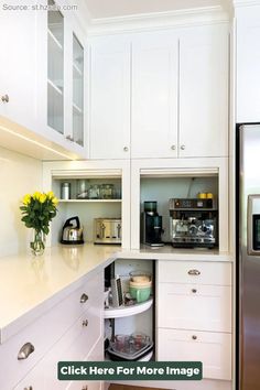 a kitchen with white cupboards and an open coffee maker on the counter next to a stainless steel refrigerator