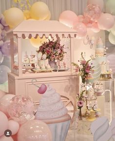 a pink and white birthday party with balloons, cupcakes, cake and decorations